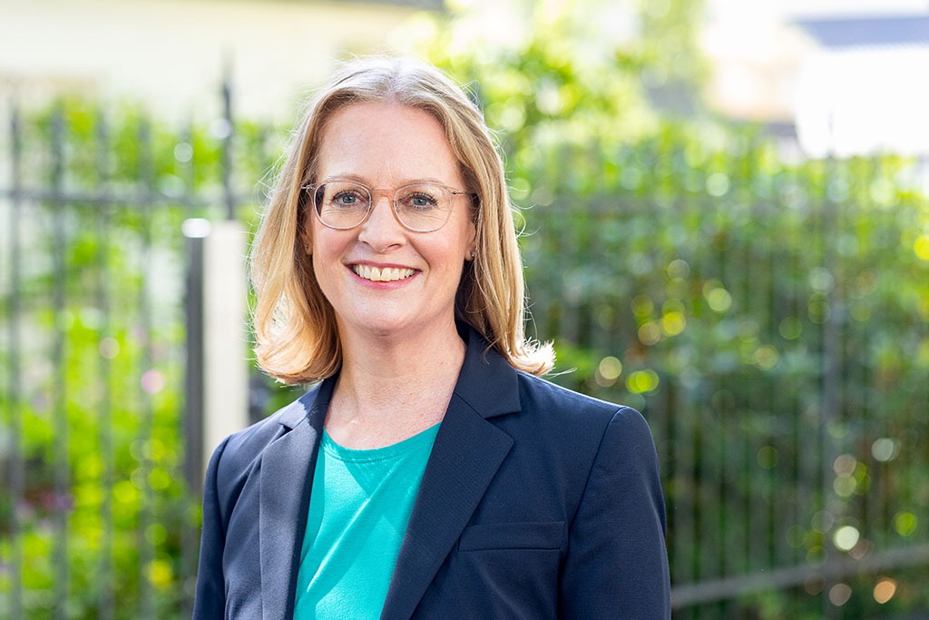 Klassisches Businessporträt in Köln eines Managers. Im Hintergrund ist es grün. Es ist Sommer.