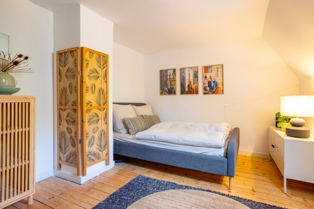 Ein Zimmer mit einem egmütlichen Bett